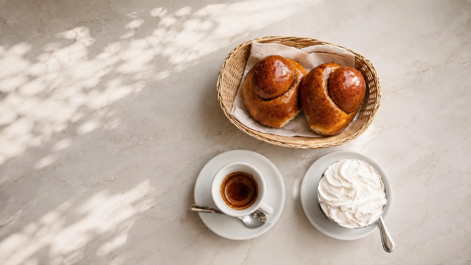 Colazione siciliana sul marmo: brioche col tuppo, espresso e panna